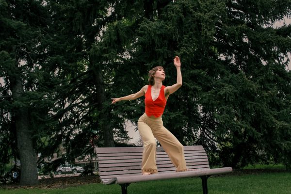 Alumni Choreographer Grace Cooper pictured in red top on bench outside